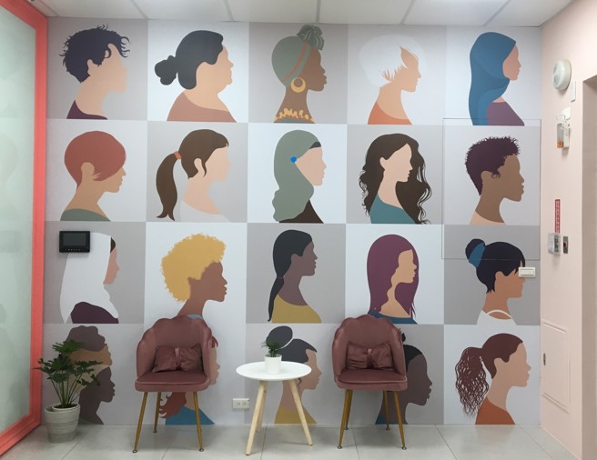 如同墙面彩绘的多元族群，中心的服务专线亦支援多国语言，能协助不同国籍女性移工解决问题。（图／桃园市政府提供）