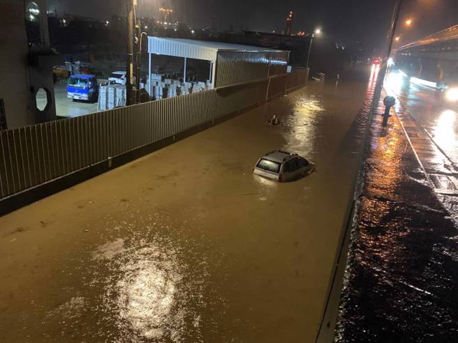 台61平面道遭淹没，一台车辆险遭淹没，警消用救生圈救出差点灭顶女驾驶。(大园分局提供)