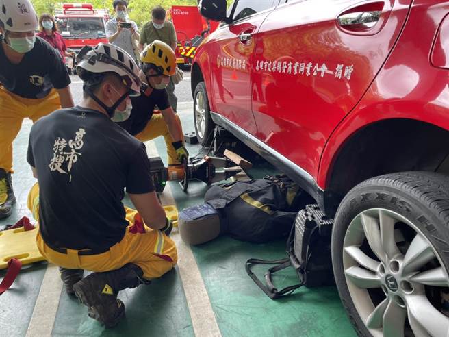 隊員示範如何將受困在車底下的患者救出。（洪靖宜攝）