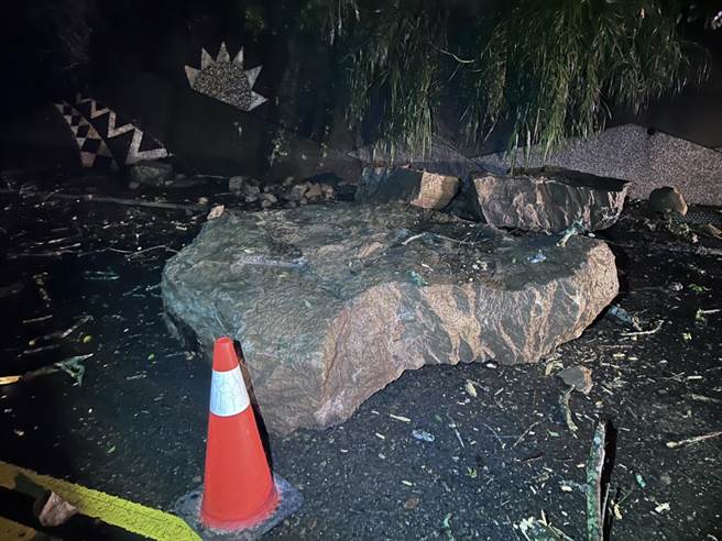 1颗约有1吨重大落石躺在路中，及其他零星小落石，员警冒雨实施交管。（警方提供）