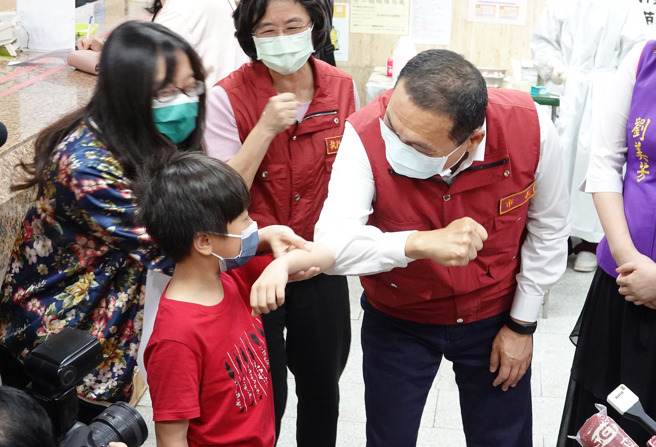 新北市长侯友宜（右）28日前往板桥区萧中正医院视察莫德纳与BNT儿童疫苗接种情形，并与勇敢的小朋友击肘。（姚志平摄）