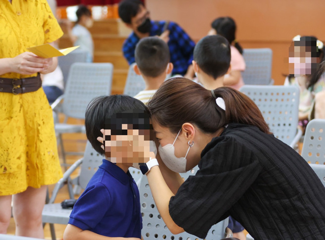 本土疫情升溫，不少家長帶孩子去打疫苗。（羅永銘攝）