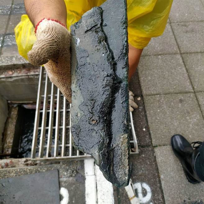 台中捷运南屯站周边排水沟，遇到大雨，大量雨水就从孔盖内喷涌出，台中市议员何文海与养工处人员开盖才发现沟内堆积有许多大小不一的水泥块。（何文海提供／谢琼云台中传真）