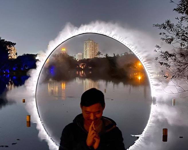  電影「奇異博士2」中的經典場景「魔法傳送門」與2022台灣燈會作品「弧零：月食」神似，澳籍藝術家利用水面倒影和燈光創造火霧圓環，吸引不少影迷前往衛武營北湖打卡朝聖。（圖/ 中央社）