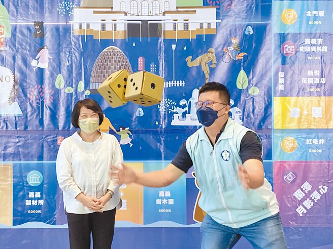 嘉义市长黄敏惠（左）、市府建设处长田长沛体验「好礼嘉在」桌游掷骰子，激推玩桌游拿优惠好康。（廖素慧摄）