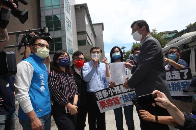 國民黨立法院黨團總召曾銘宗（中）等立委，集體前往刑事局自首「散布假消息」，由刑事警察局副局長黃家琦（右）接過文件。 （陳君瑋攝）