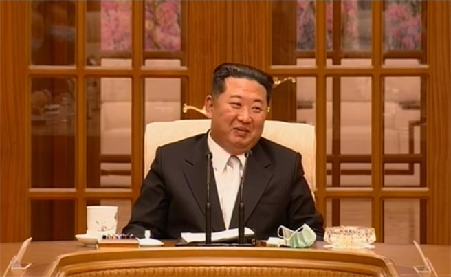今年5月12日，金正恩于劳动党中央政治局会议，身着白色衬衫，颈部被勒得很紧，脸庞圆润发福明显。（图／翻摄朝鲜中央电视台）