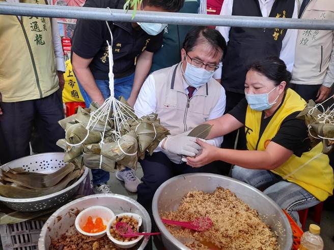 市長黃偉哲（右二）今天也在下營上帝廟，體驗包粽子。（下營區公所提供／張毓翎台南傳真）