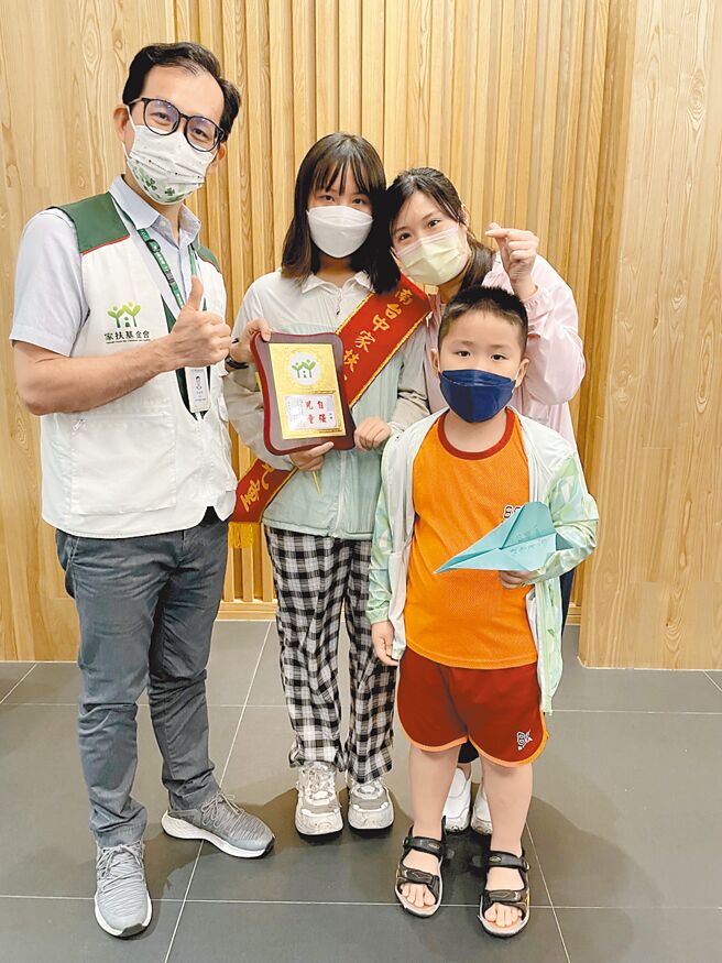国一少女小仅（左二）获家扶自强儿童表扬，是妈妈（右二）心中最大的骄傲，弟弟也跟着到场观礼。（南台中家扶提供／谢琼云台中传真）