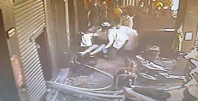 高雄市三民區28日發生住宅大樓失火，救出一對陳姓兄弟，消防員將受困屋內的哥哥救出後，將他抬至擔架，交由救護人員送醫急救。（翻攝照片／崔正綱高雄傳真）