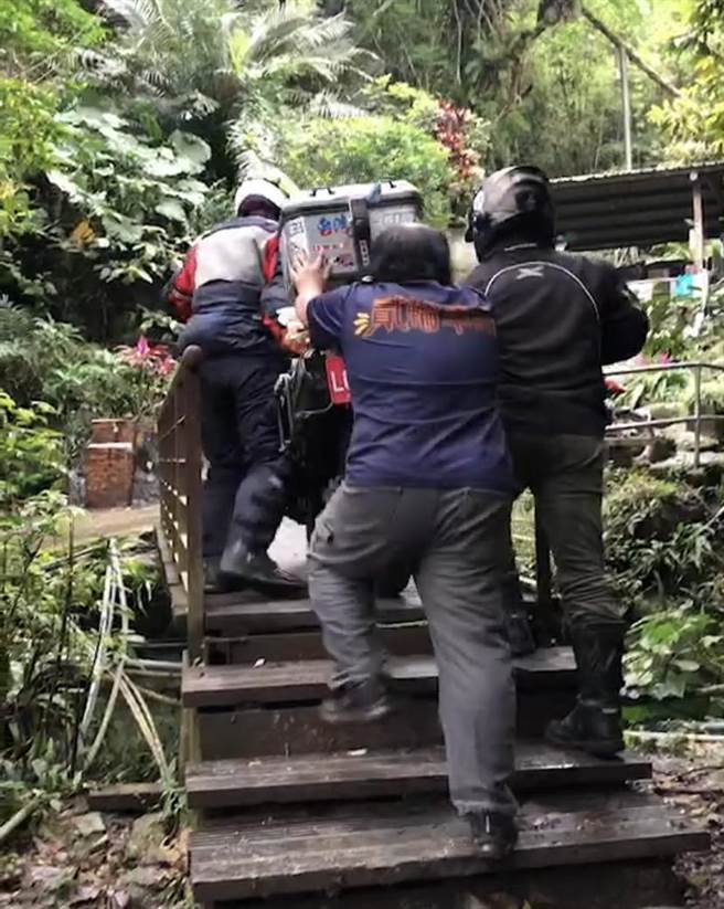 重機騎士騎上木棧橋打滑跌倒，索性由另外2名車友共同將重機抬上木棧橋。（民眾提供／吳佩蓉宜蘭傳真）