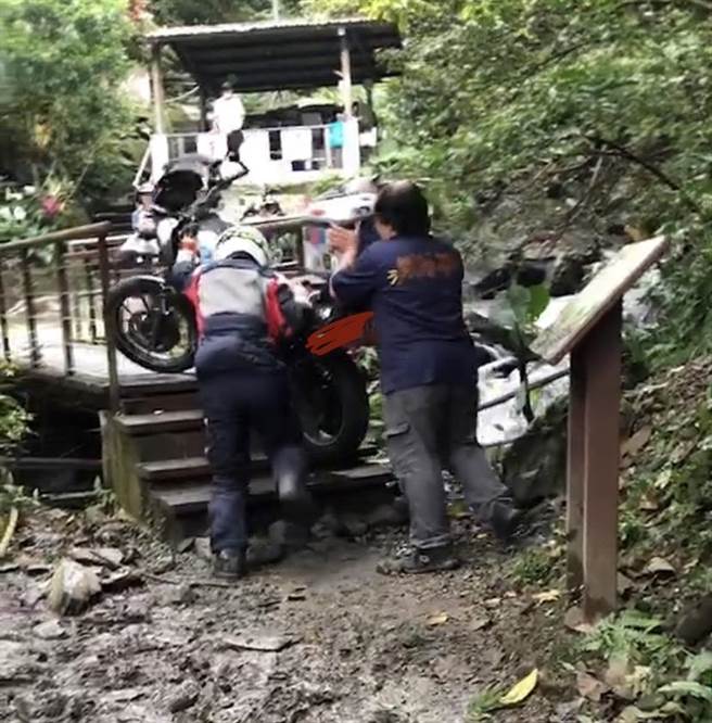 重機騎士騎上木棧橋打滑跌倒，索性由另外2名車友共同將重機抬上木棧橋。（民眾提供／吳佩蓉宜蘭傳真）