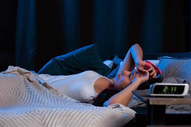 睡前滑手机的习惯会影响睡眠时间，或造成生物时钟混乱等问题，让许多戒不掉这个习惯的人每天睡前都在挣扎。（图／Shutterstock)