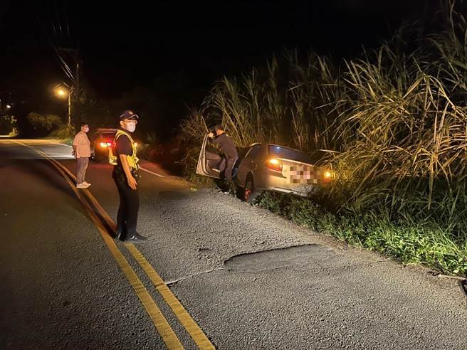 陳姓男子為閃避路中犬隻，不慎衝向路旁草叢堆受困而進退不得。（警方提供）