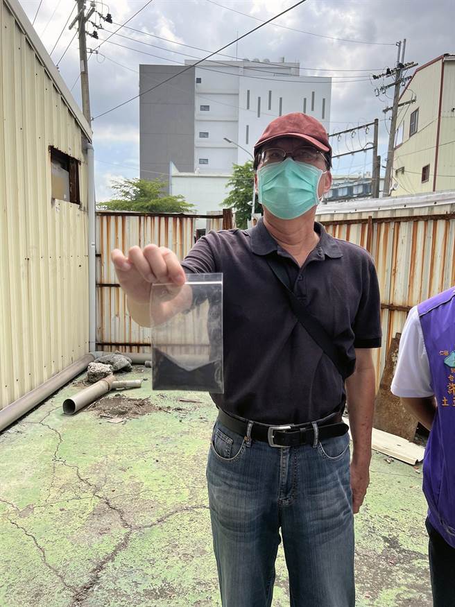 台南社大环境行动小组召集人黄焕彰手持集尘灰，指含超标的戴奥辛、锌、铜。（洪荣志摄）