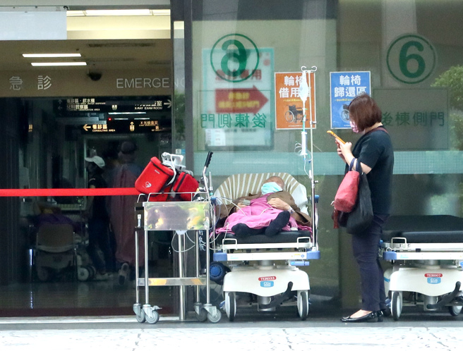 医院的急诊室外，病患躺在病床上等待就医。（粘耿豪摄）