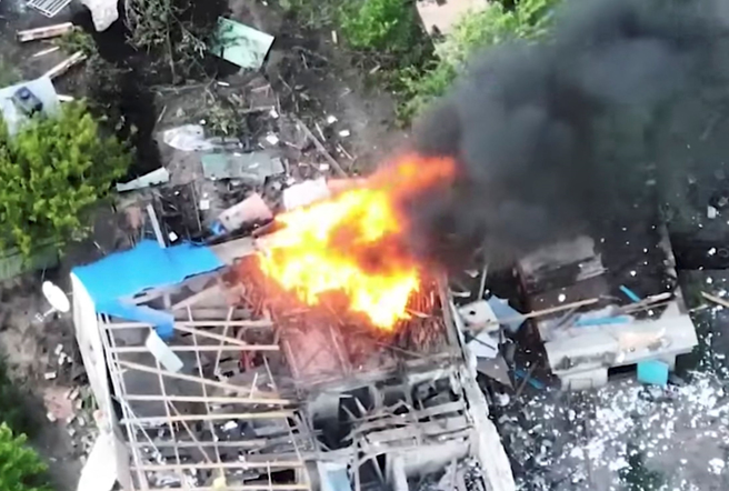 俄軍5月26日攻擊盧甘斯克（Luhansk）區，一幢建築爆炸著火的畫面。（路透）