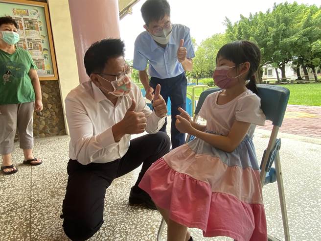 屏东县长潘孟安(左)视察校园儿童疫苗施打情形，并为学童加油打气。(屏县府提供)