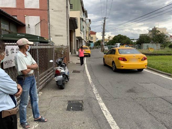 斗六市後庄里民抗議尊龍會館的隔離者行為脫序時，多輛防疫計程車又到來在外等候。（周麗蘭攝）