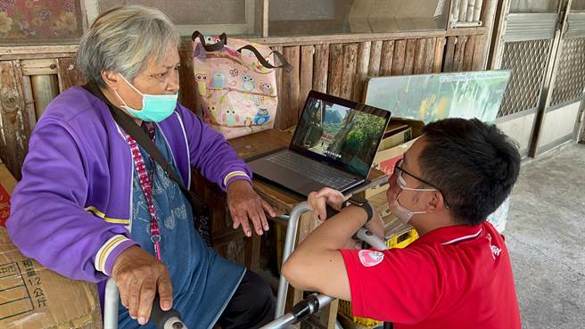 社工师林伟峯分享老人食堂的影片给阿美阿嬷。（中华圣母基金会提供／张亦惠嘉县传真）