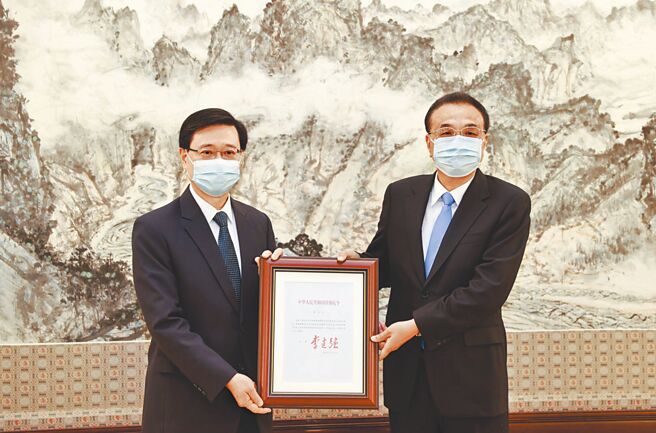 大陆国务院总理李克强（右）30日在北京中南海紫光阁会见候任香港特首李家超，颁发国务院754号令任命状。（新华社）