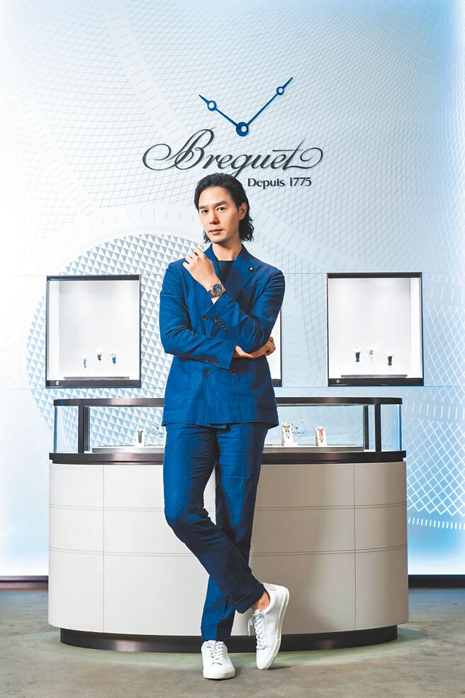 艺术策展人丁春诚以蓝色西装佩戴宝玑Marine Hora Mundi 5557玫瑰K金腕表。（Breguet提供）