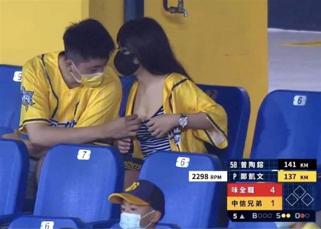 男球迷伸手將髒東西從女球迷胸口拿出，畫面讓網友看得血脈賁張。（圖／取自爆廢公社公開版臉書）
