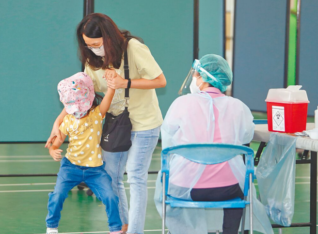 家長帶小孩打疫苗，結果小朋友臨時反悔，與媽媽拉扯。（陳怡誠攝）
