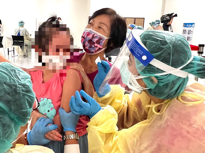 疫情尚未趨緩，中正紀念堂兒童BNT疫苗接種站1日啟用，家長帶孩子去打疫苗。（范揚光攝）