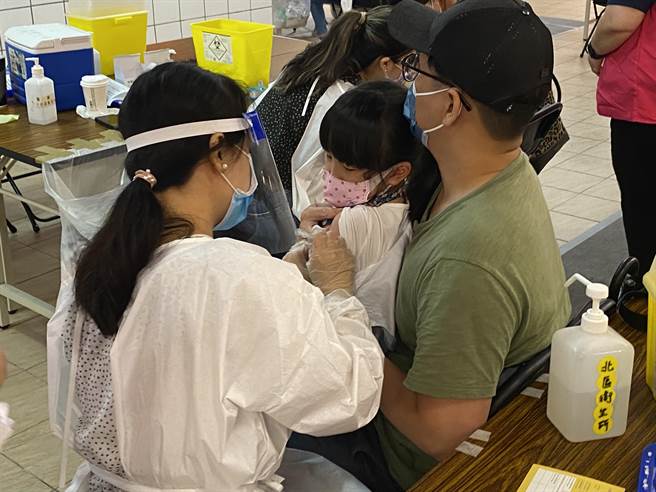 本土疫情持續未降溫，考量兒童染疫風險，新竹市長林智堅1日傍晚宣布，新竹市高中、國中、小、公立幼兒園學校學生自6月6日至6月10日維持停止實體上課。圖為家長帶著孩童至社區疫苗接種站施打疫苗情形。（陳育賢攝）