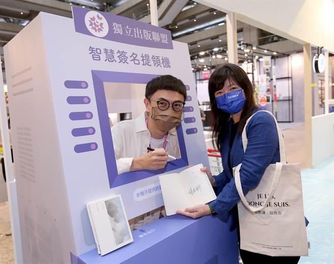 第30届台北国际书展于端午连假期间，6月2日至7日在台北世贸一馆举行，「读字便利店」将展区设计成超商的样子，设计模仿ATM的智慧签名提领机，让独立出版书籍的作者坐在里面为读者签名。文化部次长李静慧（右）1日率先体验开箱。（黄世麒摄）