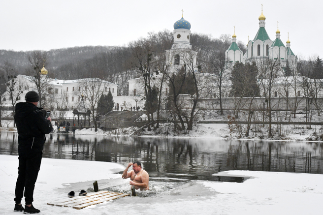斯维亚托戈尔斯克洞窟修道院（Sviatohirsk Lavra），信徒正透过进入结冰河流完成传统仪式（图/美联社）