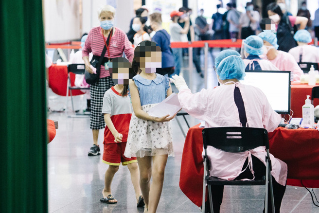 本土疫情尚未趨緩，不少家長帶著孩子去打兒童BNT疫苗。（郭吉銓攝）