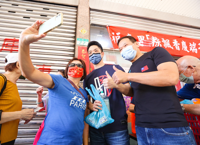 国民党北市长参选人、立委蒋万安（中）和市议员锺小平（右）2日出席万华区福音里端午节活动，民眾和他们一起合影留念。（罗永铭摄）