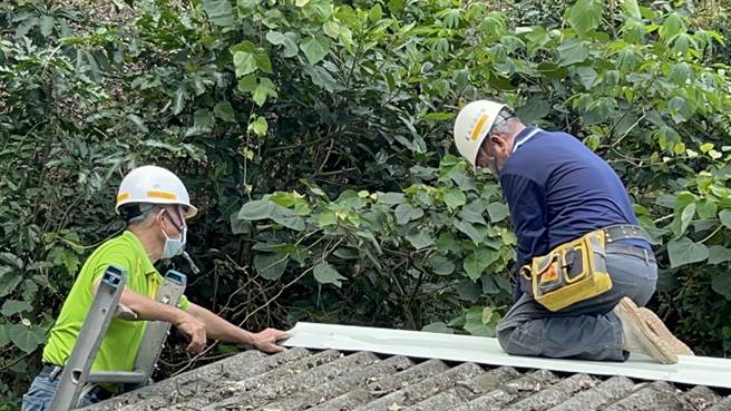 修缮志工爬上屋顶施工。(台南市劳工局提供／刘秀芬台南传真)