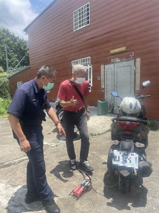大湖警分局梅園所長陳樹成協助藍姓民眾機車充氣。（大湖警分局提供／謝明俊苗栗傳真）