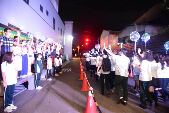 侨泰中学的毕业生在师生们欢送下，带着离情步出校园。(校方提供／林欣仪台中传真)