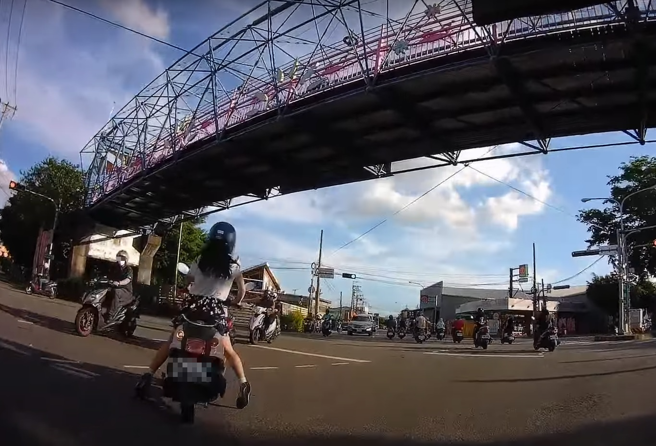 有名正妹骑机车欲左转遭后方骑士按喇叭示警，该名正妹竟手摧油门「双脚煞车」差点爆衝出去。（翻摄自YouTube频道「WoWtchout - 地图型行车影像分享平台」）