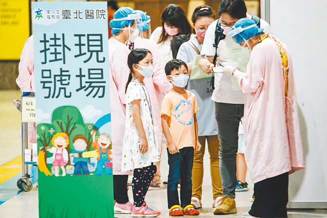 中央1日起在六都設置大型兒童疫苗接種站，一早陸續有家長帶著孩子前往新北市板橋車站掛號打疫苗。（郭吉銓攝）