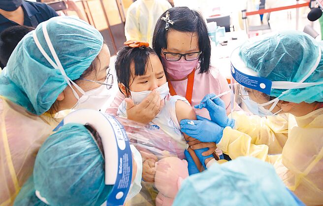 中正纪念堂儿童BNT疫苗接种站1日启用，1名幼童扎针时吓得嚎啕大哭，大人们只好紧紧抱住她。（范扬光摄）