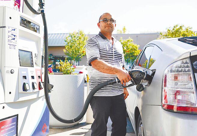 圖為一名車主在美國加州米爾佈雷的一家加油站為汽車加油。（新華社）