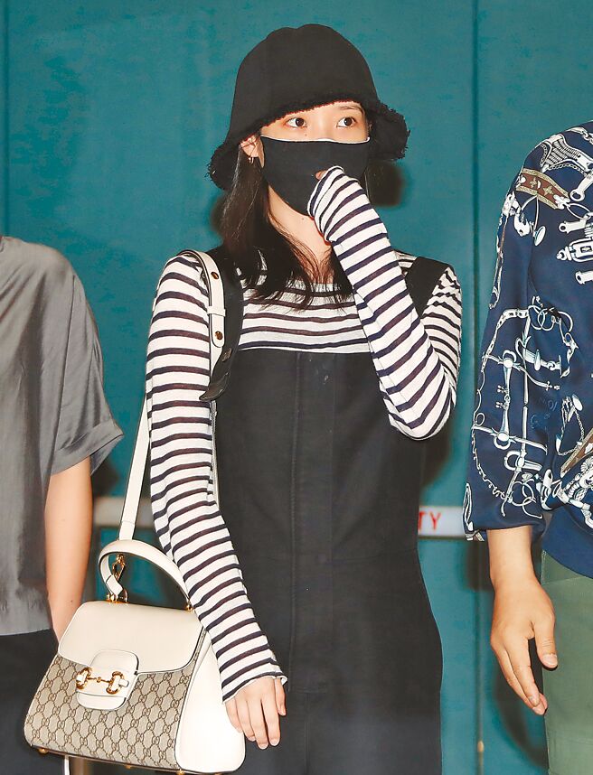 IU返回韩国时背Gucci Horsebit 1955白色皮革老花帆布手提包，包的小巧尺寸让她看来轻盈可爱。（CFP）
