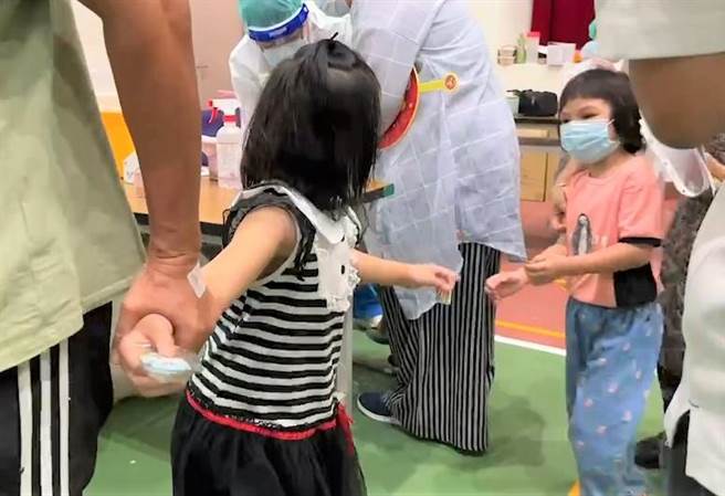 台東1對雙胞胎姊妹在快打站輪流施打疫苗，施打完的姊姊（左）轉頭向妹妹（右）信心喊話「不要怕！」（蔡旻妤攝）