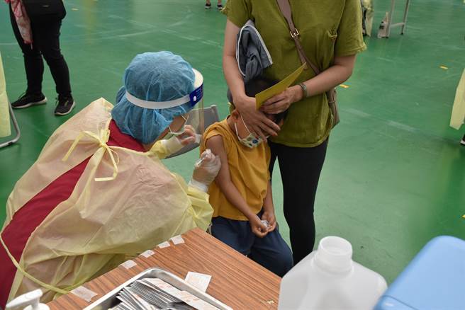 國採購的幼兒BNT疫苗將於本周到貨，最快下周完成檢驗封緘後即可開始接種。圖為小朋友害怕躲在家長懷裡完成接種。（資料照 謝明俊攝）
