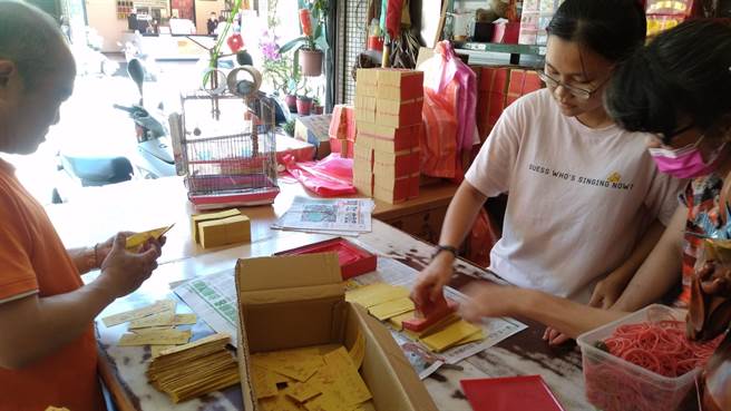 上午一家三代总动员制作清净符。（读者提供／张毓翎台南传真）