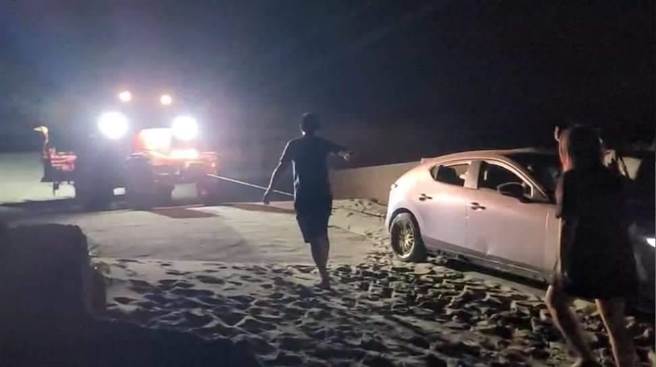 竹南警分局外埔派出所员警协助受困水尾沙滩民眾座车脱困。（竹南警分局提供／谢明俊苗栗传真）