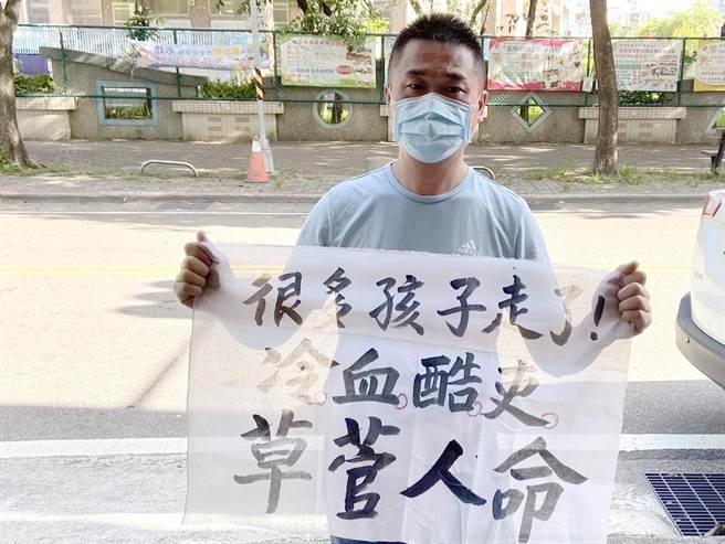 行政院長蘇貞昌視察台中兒童疫苗快打站，中市里長鄭伯其舉白布條嗆「冷血酷吏草菅人命」。（鄭伯其提供）