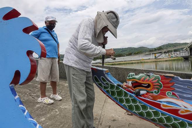 因为选手练习操作不当而损毁龙舟，开赛前一天，负责现场的体育局陈姓组长还要顶着烈日，跟着刘清正紧急修復两艘断头断尾的龙舟。（黄子明摄）