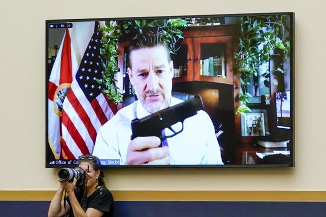 史杜在视讯听证会上掏出手枪。（图／美联社）