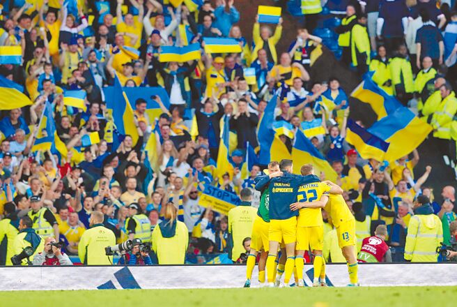 乌克兰3比1击败苏格兰之后，球员在3000名客队球迷的看台前拥抱庆祝。（美联社）